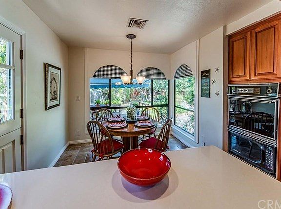 Remodeled kitchen has quartz countertops and a Dutch door. View of the breakfast nook at rear.