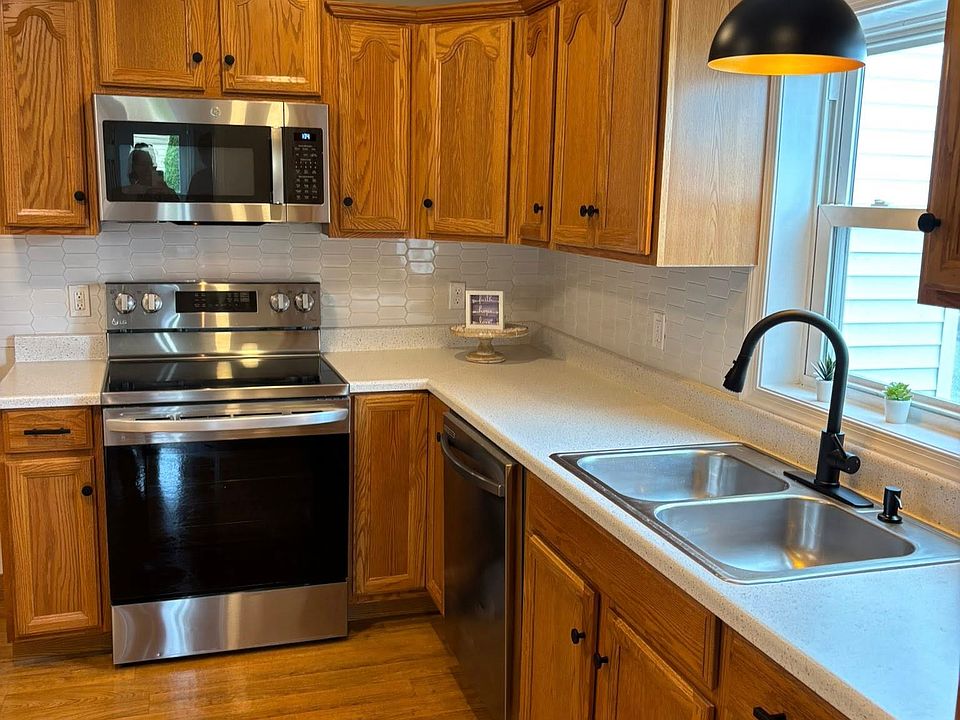 Large eat in kitchen with brand new countertops, a new dishwasher and microwave and lots of cabinet storage space.