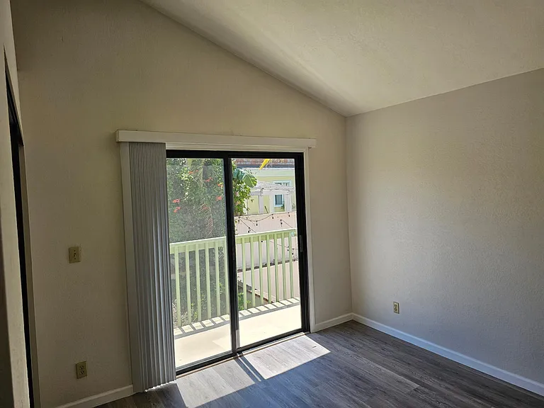 Upstairs 2nd bedroom with vaulted ceiling and deck.