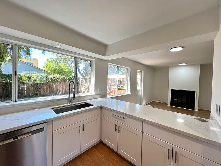 Open floor plan with kitchen and living room looking out to backyard