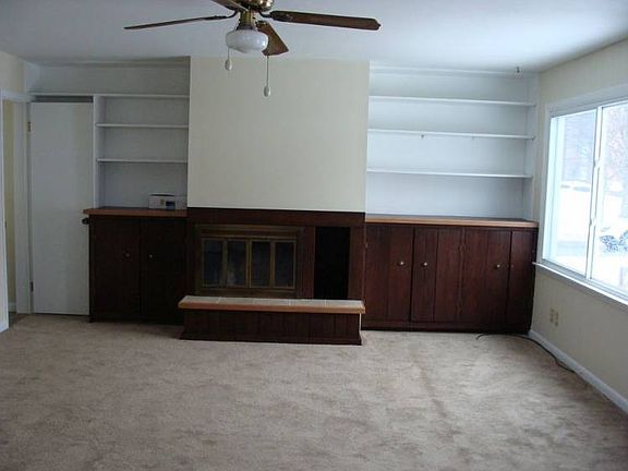 br /br / Cozy living room with bookcases ,ceiling fan and fireplace.