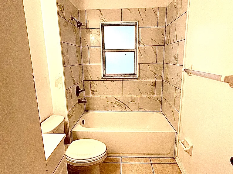 Hall Bathroom with new tub, window, and shower tile.