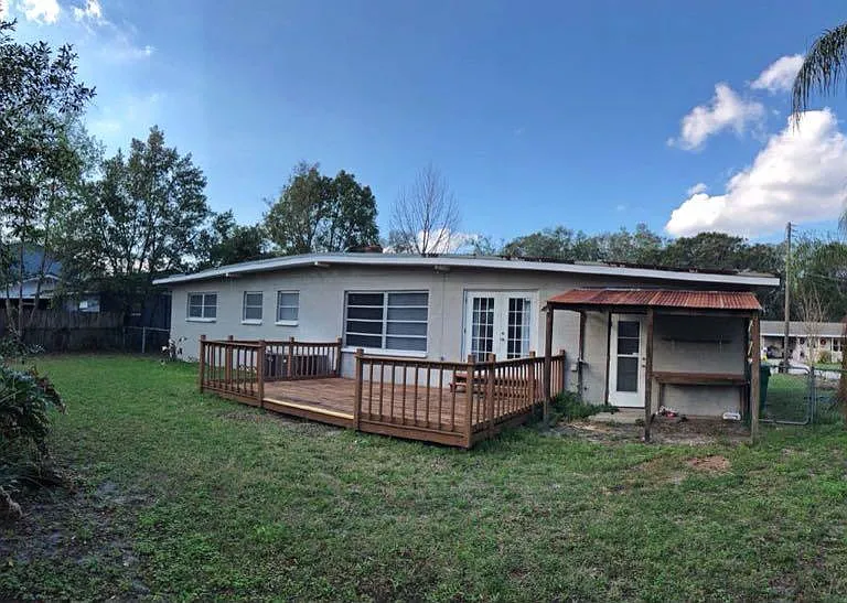 Older photo of large back yard, taken prior to deck refinishing.
