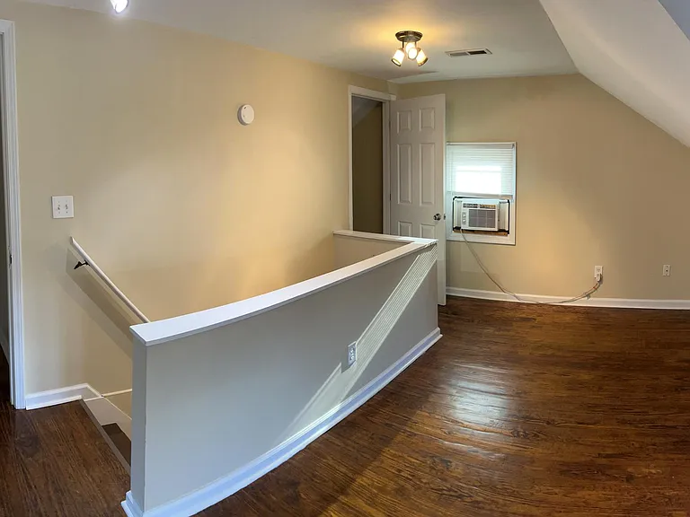 Second floor, view 3 - walk-in closets on each side of stairwell. Landlord supplies window unit to boost HVAC cooling when needed.