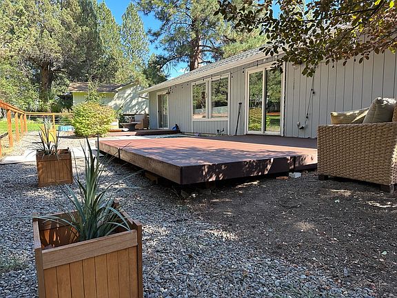 Freshly stained deck, view from one end of large backyard with new fence