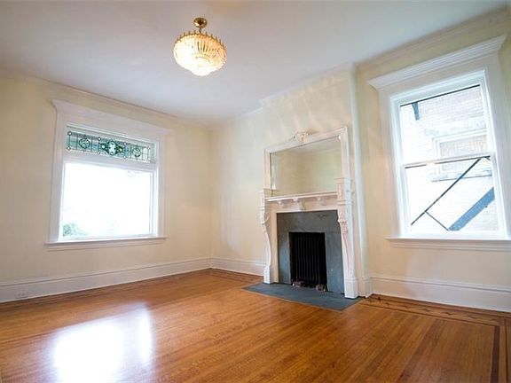 Beautiful living room (20x15) with hardwood floors, decorative fireplace with mantle and leaded glass window transom.  Pocket do