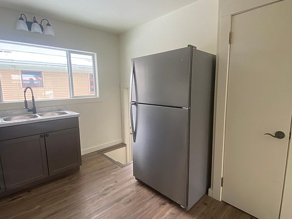 Stairs to go downstairs are between kitchen sink and fridge