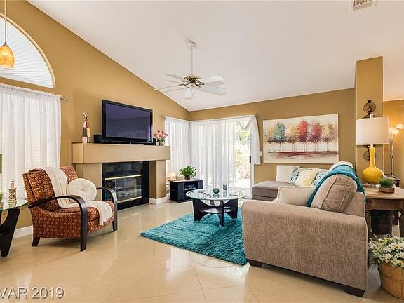 Living room has vaulted ceilings and a fireplace with a granite surround...