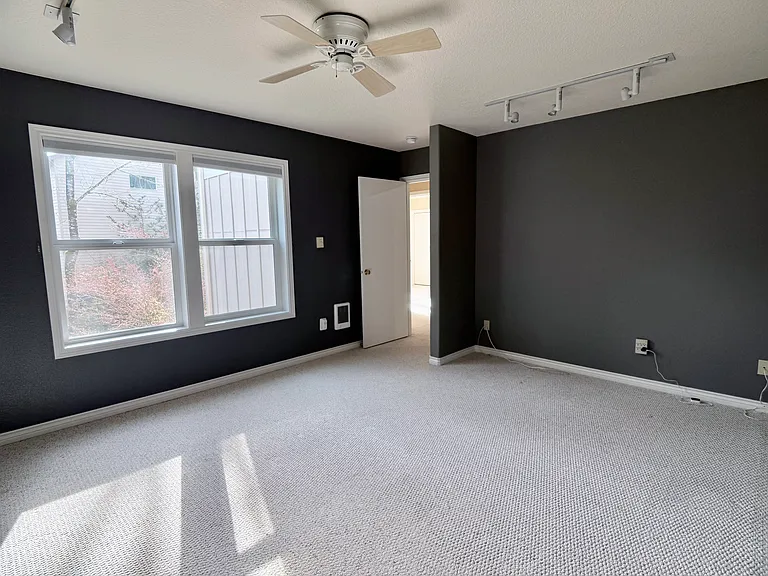 Spacious secondary office in a private wing, featuring a ceiling fan and a flexible layout ideal for work or creative use.