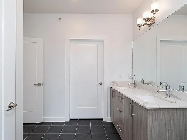 Huge Master Bath with Tile Floors, Double Vanity, Quartz Countertops, Chrome Fixtures and Contemporary Lighting.