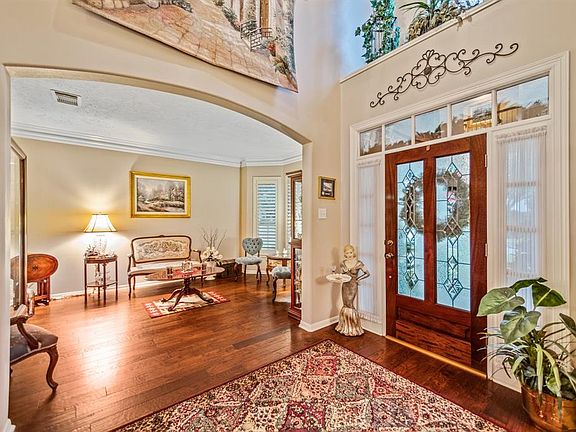Beautiful entry with leaded glass doors and rich wood flooring.