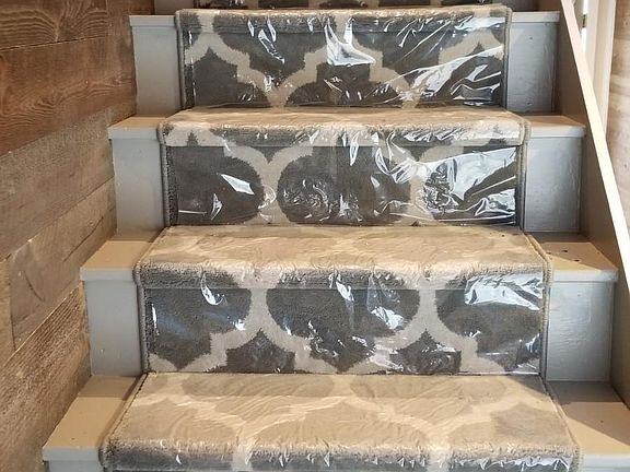 Stairs leading to main floor with accent wall on the left.