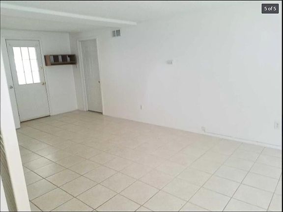 Family room with door leading into 3-season room and door leading into garage.