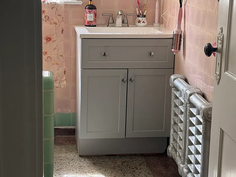 The original terrazzo floor gives the apartment a cool vintage vibe. The vanity has been updated and the tub reglazed.