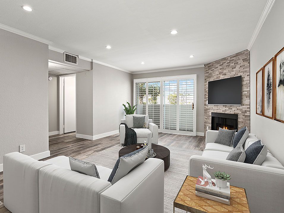 Hardwood floored living room with stone accented fireplace.