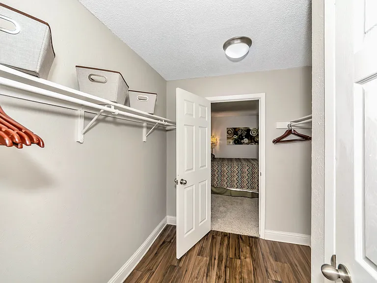 Spacious walk-in closet with built-in shelving for organized storage.