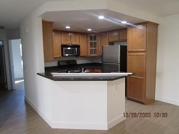 Kitchen with stainless steel appliances, lots of cabinets, granite counter tops and updated lighting to modernize and brighten the area.