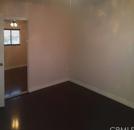 Master bedroom with hardwood floors, ceiling fan and mirrore