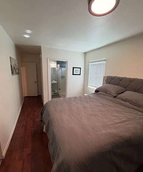 Primary bedroom looking into bathroom and hallway
