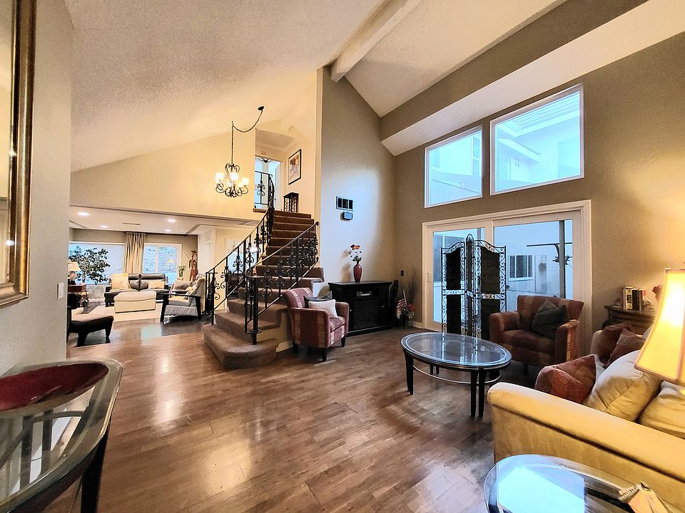 View of living room, stairs, and family room in the background.