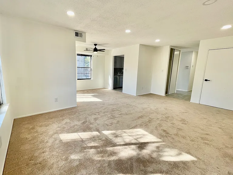 Living area view, open into the dining area & kitchen on the far left and hallway to bedrooms & bathroom on the far right