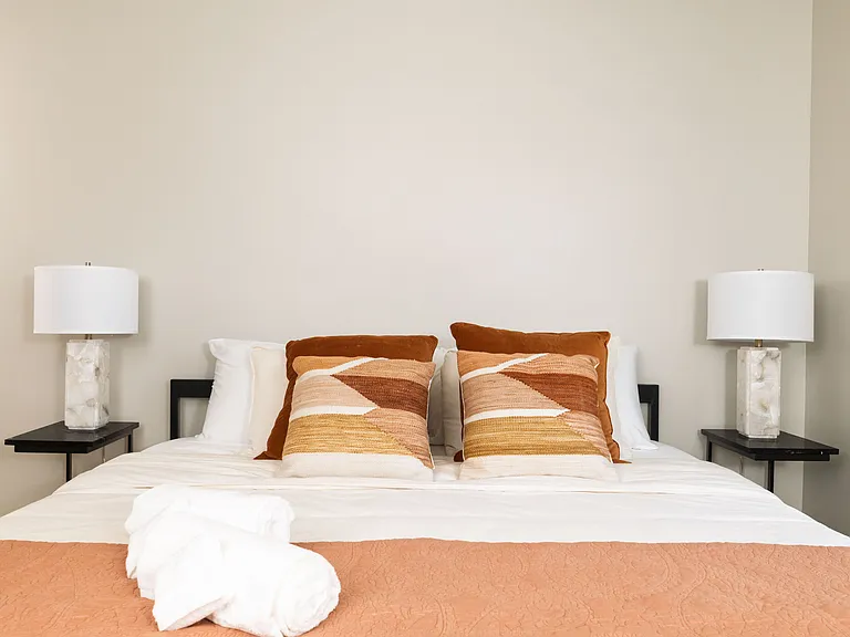 Primary bedroom with king bed, attached bathroom and ceiling fan.