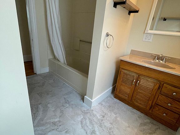 Bathroom with new floor, toilet, and fixtures.