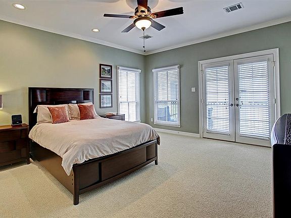 Oversized master suite is bright and airy with updated ceiling fan and French doors leading out onto a private balcony overlooking the lush tropical f
