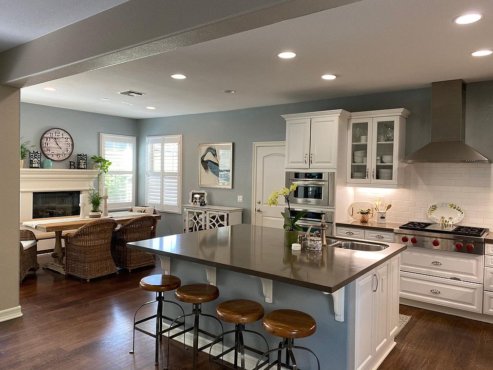 Barstools and dining table with chairs and white china cabinet included in furnishings.