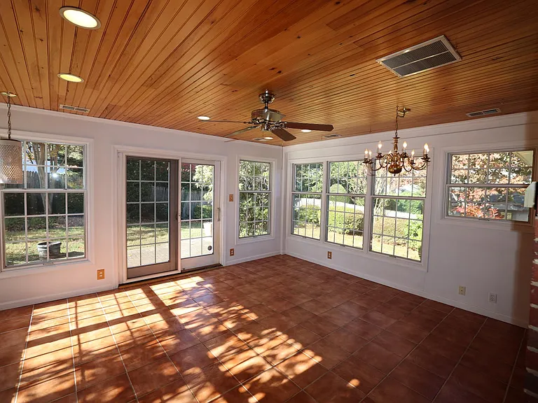 Sun room with windows on all sides, has access to the backyard via smooth sliding glass doors.