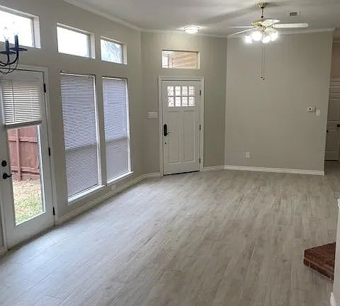 Walk in living room with brick fireplace. Note the upgraded wood look grey tile in main areas.