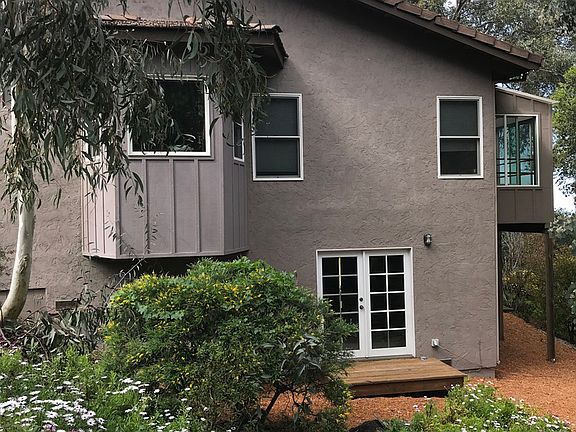 Right side of house showing sun room and french door from the downstairs bedroom.