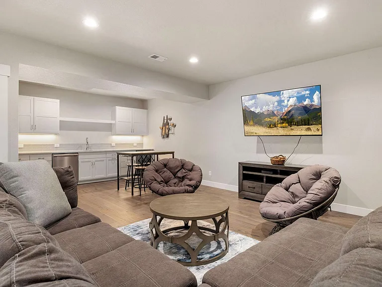 Huge basement living area with an additional sleeper sofa, seating, 65 inch Smart TV, and full wet bar!