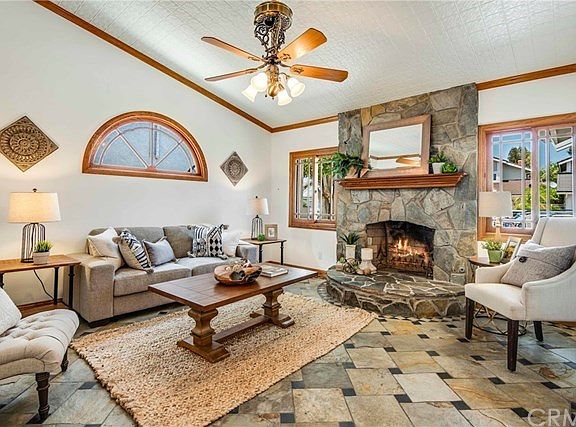 Separate formal sunken living room with vaulted ceiling is highlighted by custom fireplace with stone raised hearth and surround and custom mantle.
