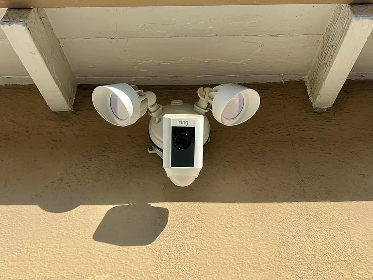 Ring camera and motion sensor lights in the driveway above the garages.