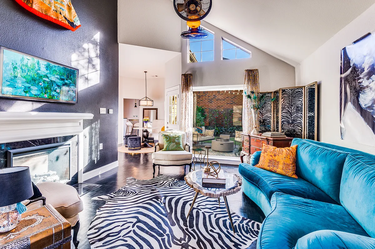 Large living area includes soaring ceilings and windows, black stained oak parquet floors, black accent wall with electric fireplace, and built in wine cooler. - 4112 Shadow Gables Dr