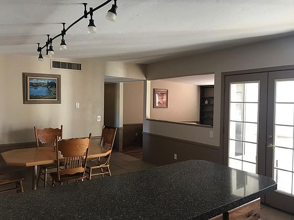 View to the dining and living rooms and the french doors leading to the private south patio and back yard with 7 foot privacy fence.