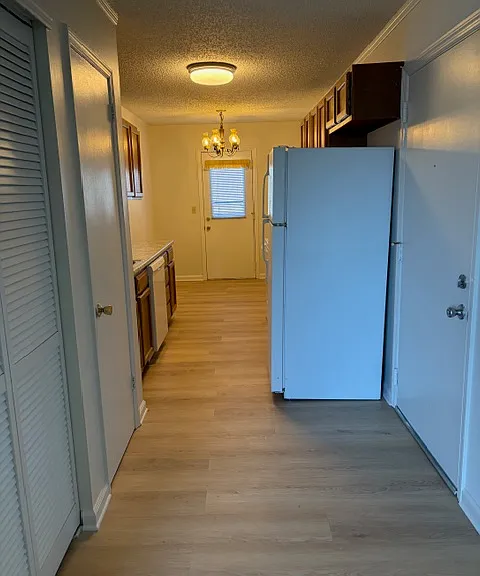Front door to the right. Length of kitchen to balcony door