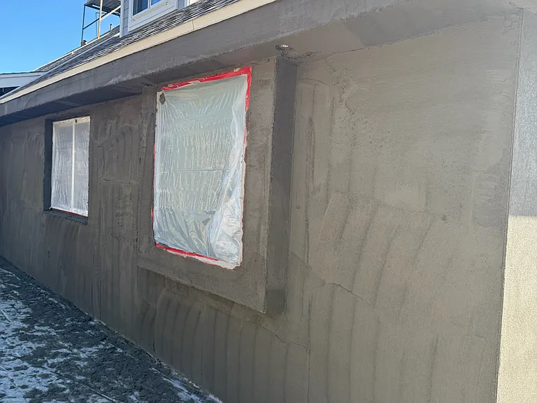 REMODELED exterior receives scratch coat of stucco