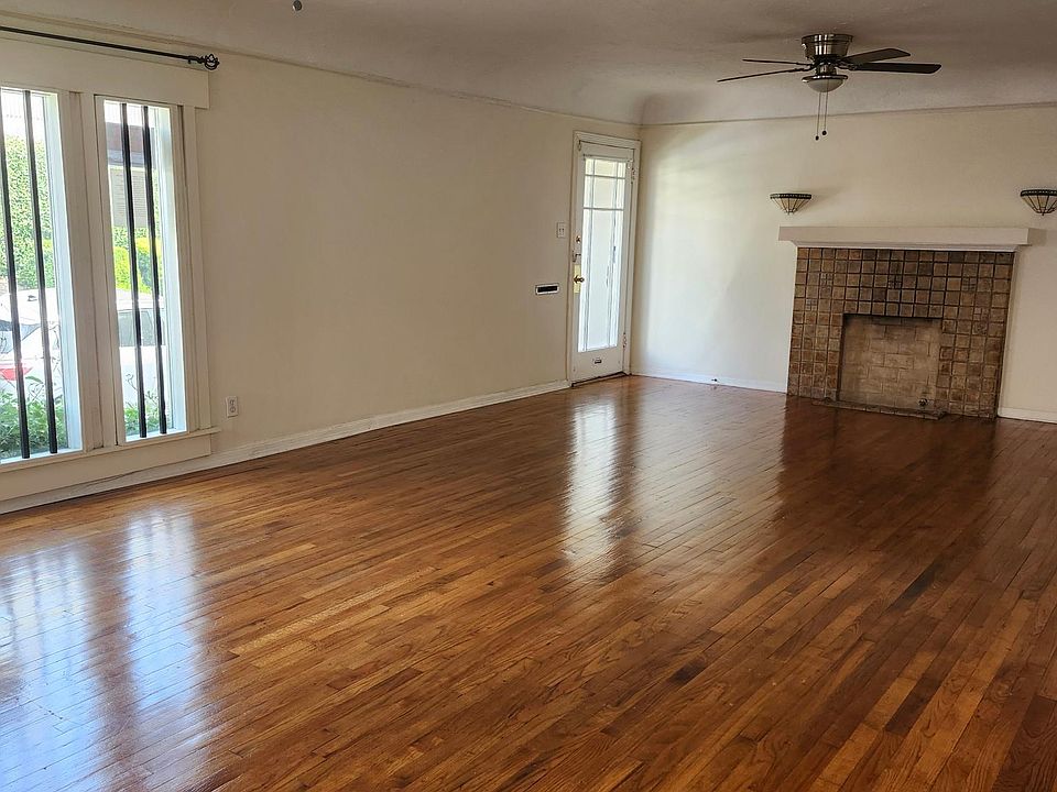 Large living/dining room area with beautiful natural light, original faux fireplace with Malibu tiles and relaxing ceiling fans. A very relaxing enviornment.
