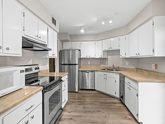 Kitchen with stainless appliances and flooded with natural light.
