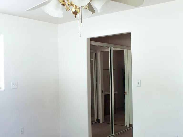 Master bedroom looking towards 2 closets with mirror doors