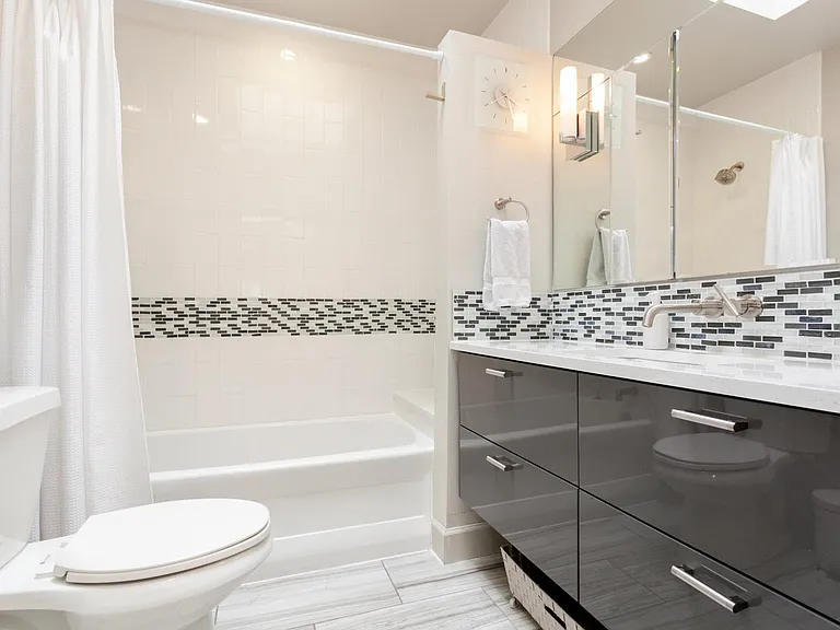 Bathroom with large lovely bathtub/ shower with the sun beating in on you from the skylight and ample drawer and medicine cabinet storage.