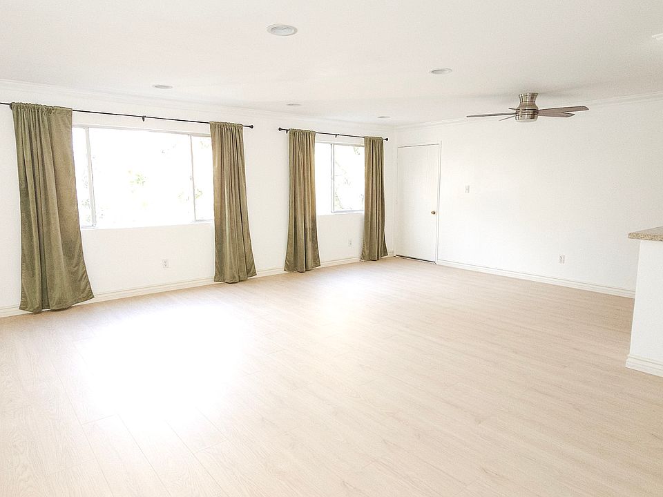 A bright, airy main living space with new laminate flooring and room for multiple furniture layouts.