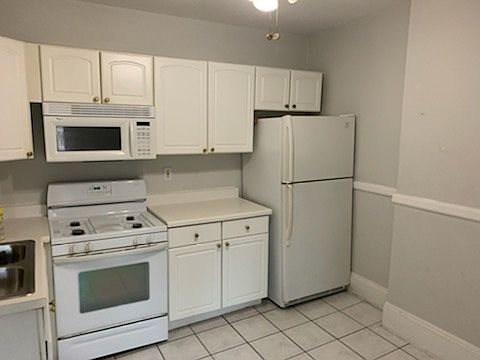 l shaped white, eat in kitchen partially pictured