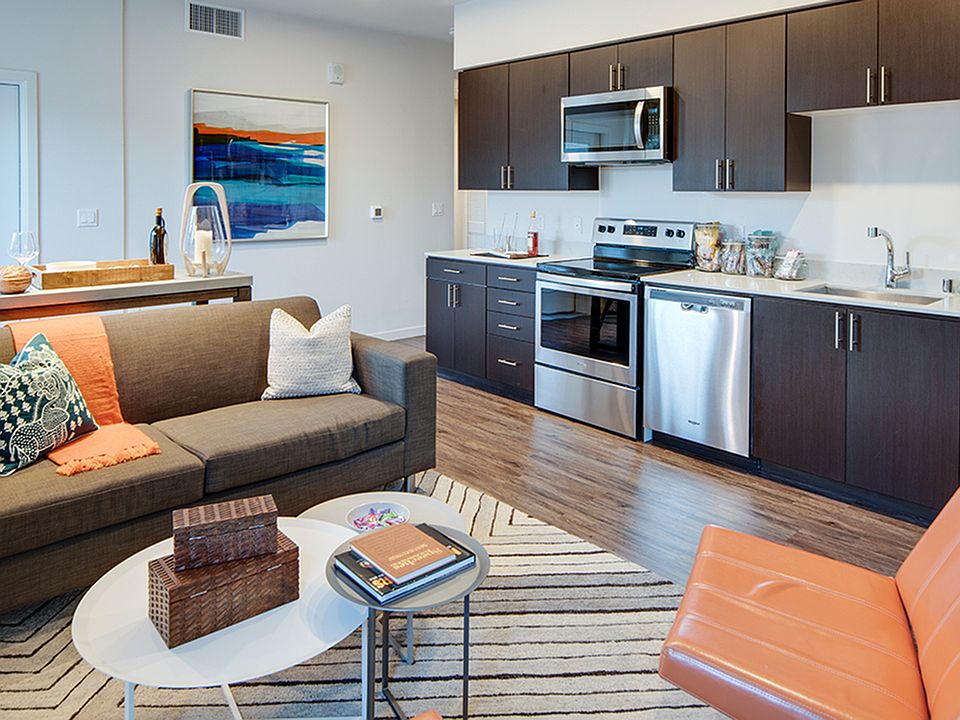 Open concept kitchen into loving room with faux wood plank flooring throughout