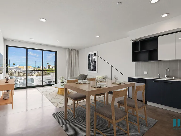 Open-Concept Kitchen, Dining, and Living Room Space with Concrete Flooring and Patio