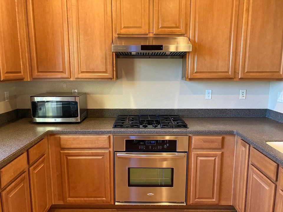Kitchen with vent, microwave, gas range, countertop oven, and dishwasher