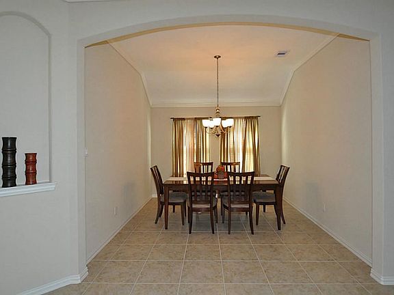 Formal dining room is adjacent the kitchen.  Features include a double window and crown molding with art niche at the entrance.