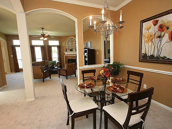 The dining room opens to the family room and has lovely crown molding, an updated chandelier, and archways.
